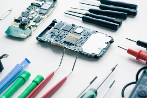 istock two damaged disassembled cellphones on a white desk with tools ready for repair 665139822