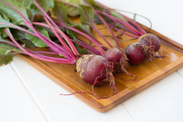 istock Fresh beetroots with leaves on white wooden table 665140650