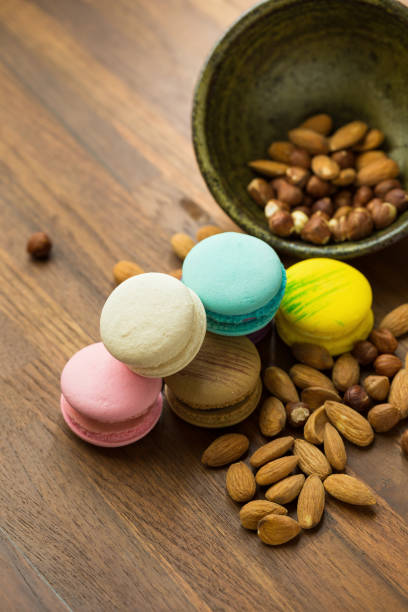Tasty macaroons and cup of milk with almond on wooden background. Selective focus