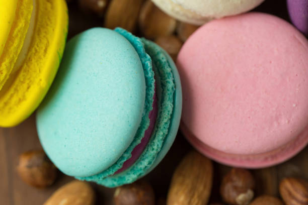 Tasty macaroons with almond on wooden background