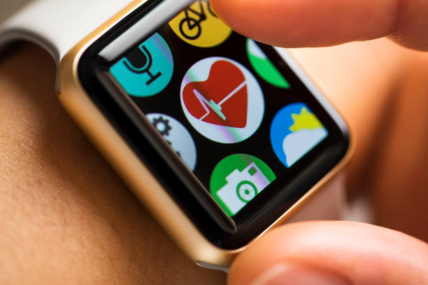Close up shot of woman wrist wearing smart watch. Finger touching health track app icon on touchscreen.