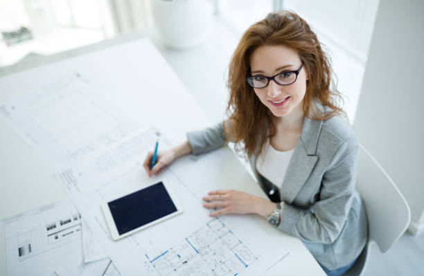 istock Beautiful female architect working on plan in company office 665153810