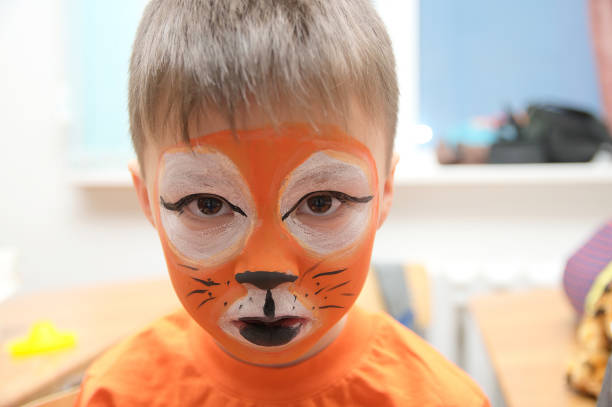 istock Make up artist making tiger mask for child 665155192