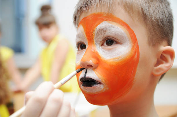 istock Make up artist making tiger mask for child 665158932