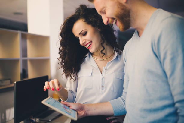 istock Happy business colleagues in modern office using tablet 665159160