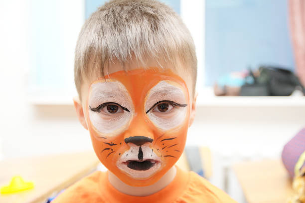 istock Make up artist making tiger mask for child 665159260