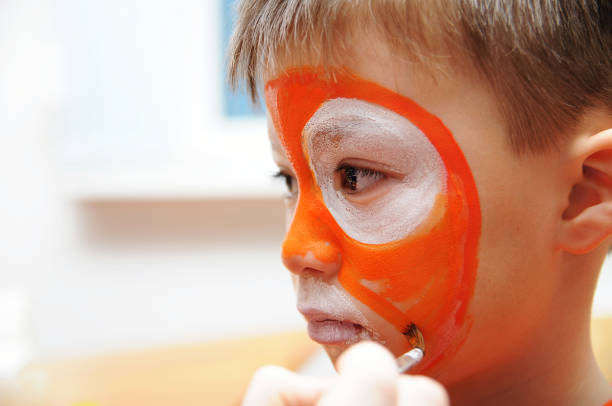 istock Make up artist making tiger mask for child 665161678