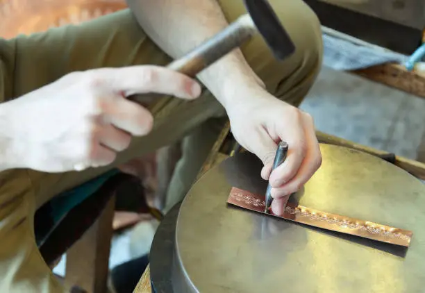 Photo of Craftsman makes copper bracelet
