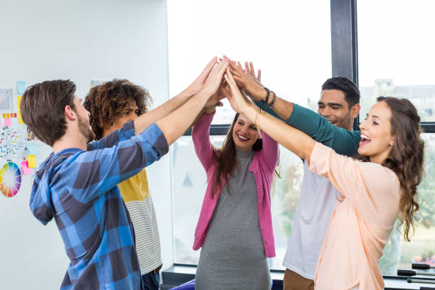 istock Team of happy graphic designers giving high five 665169928