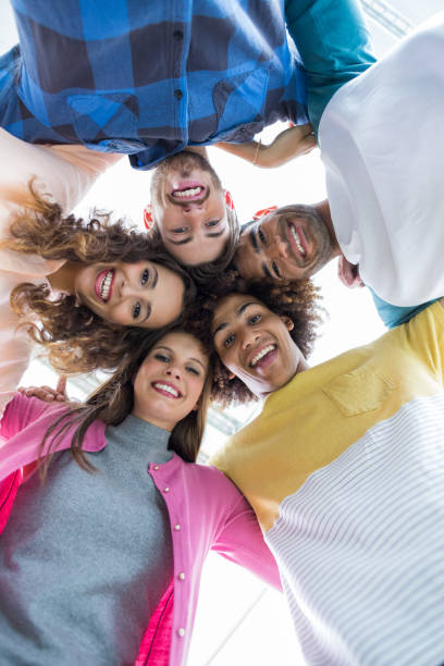 istock Team of smiling executives forming huddle 665171010