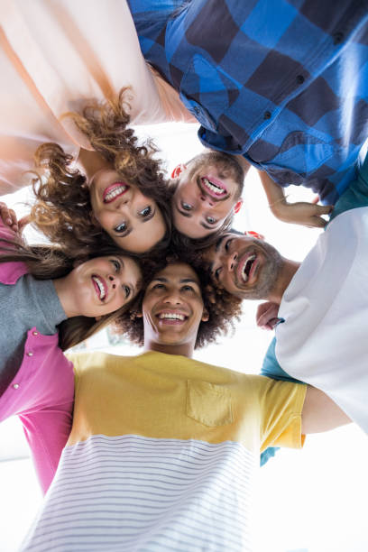 istock Team of smiling executives forming huddle 665171344