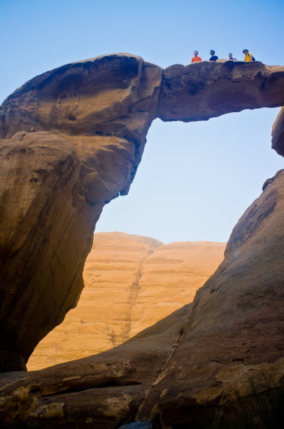 Tourists exploring ancient rocks formation in a sunny day, Wadi Rum desert. Jordan.