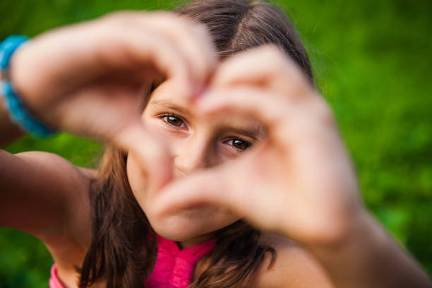 istock Girl Making a Heart Shape with Her Hands 665197030