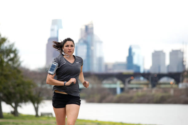 Philadelphia, PA, USA - April 4, 2017; Cherry blossoms on the Schuylkill River banks in full bloom are an attraction to many, including joggers and cyclist, enjoying the early spring weather, in the Fairmount Park section of Philadelphia, Pennsylvania.