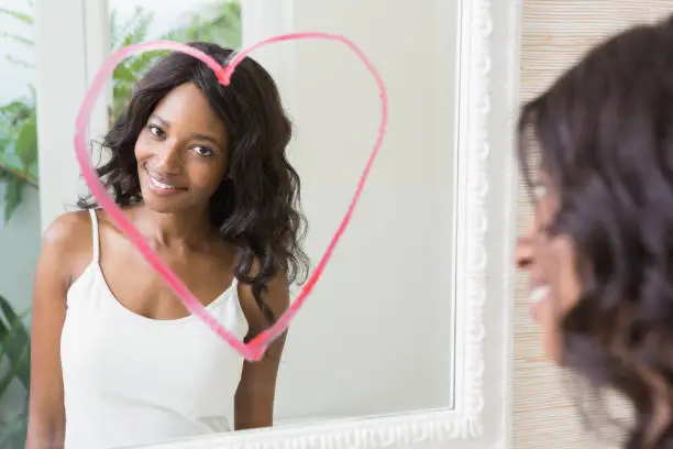 Photo of Beautiful young woman looking in the mirror