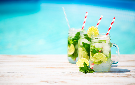 Glasses of lime lemonade near pool