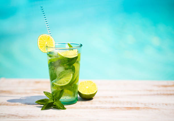 verres à cocktail au bord de la piscine, plage à côté. mojito - rebord de piscine photos et images de collection