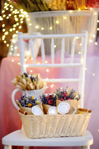 istock Beautiful dried flowers in paper boxes with lights on background 665232614