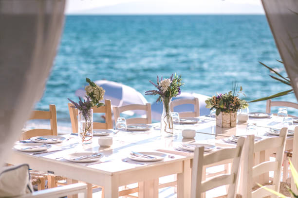 tavolo per il pranzo sulla spiaggia in grecia - restaurant banquet table wedding reception foto e immagini stock