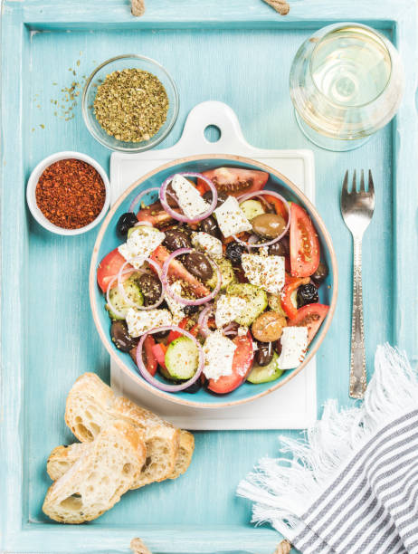 insalata greca con pane, origano, pepe e bicchiere di vino - cibo di mediterraneo foto e immagini stock