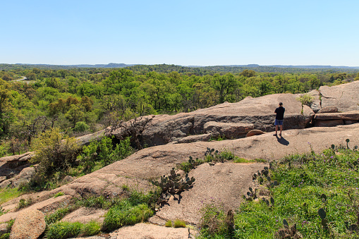 A man takes in the central Texas view from  one of the hiking trails in Enchanted Rock State Park, just ouside of Fredericksburg, Texas.