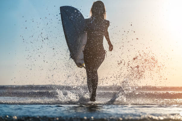 istock Young woman with surfboard 665255262