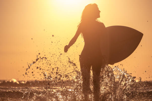 istock Young woman with surfboard 665255386