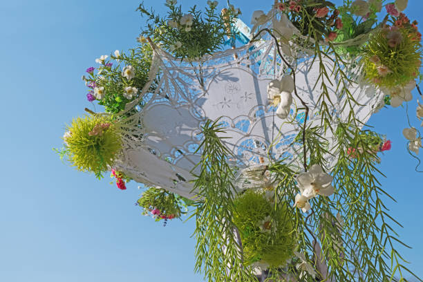 istock White umbrella decorated with flowers, against the sky. 665262896