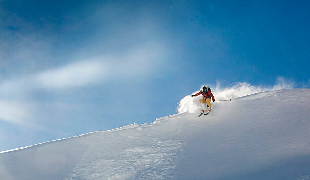 istock Skier hops over sunlit ridgeline onto powder snow 665267787
