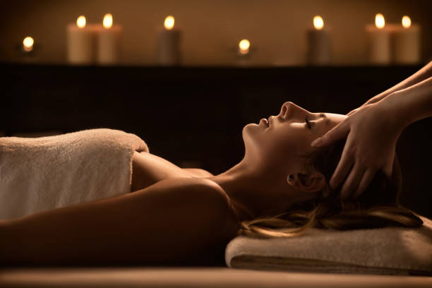 Young woman enjoys massage in a luxury spa resort The beautiful young girl getting a spa treatment. Facial massage spa stock pictures, royalty-free photos & images