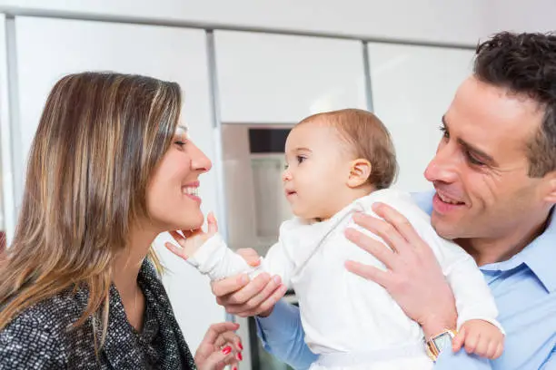 Mom, dad and baby in the kitchen preparing sweets