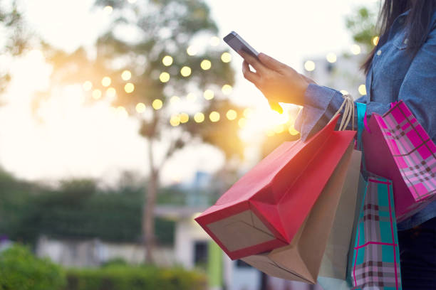 mujer con smartphone con bolsa en manos - holiday shopping fotografías e imágenes de stock