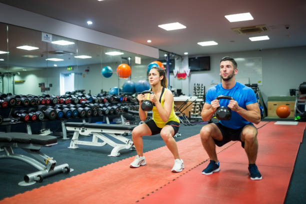 istock Man and woman working out using kettle bells 665287500