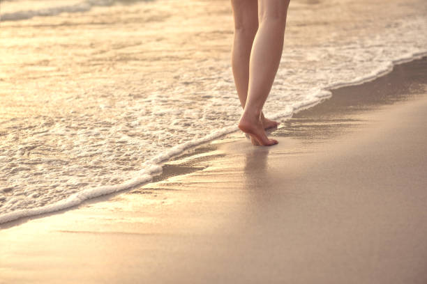 istock Woman walking on wet sandy beach 665308600