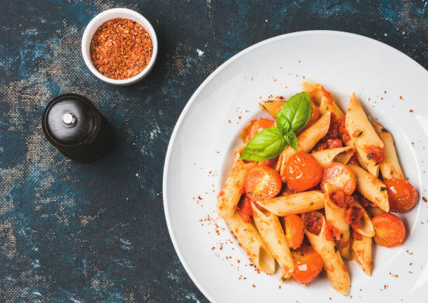 istock Pasta penne with tomato sauce, basil, roasted tomatoes. Copy space 665315778