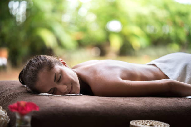 istock Smiling woman relaxing on a bed at the spa. 665318238