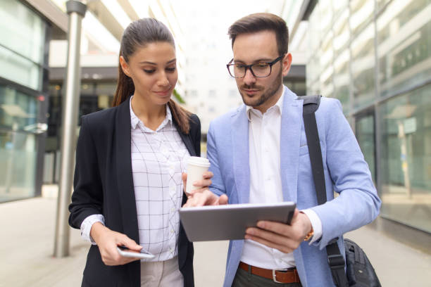 istock Business team discussing business project using tablet computer outdoors 665322402