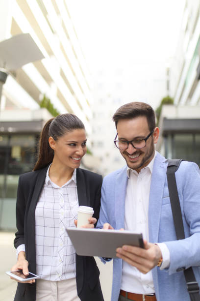 istock Business team discussing business project using tablet computer outdoors 665329360