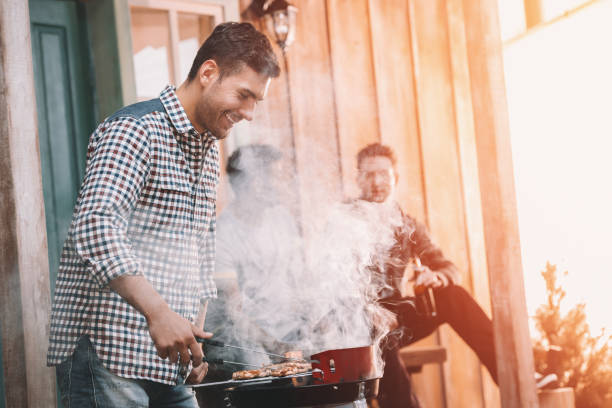 istock happy young friends making barbecue on porch with back light 665337396