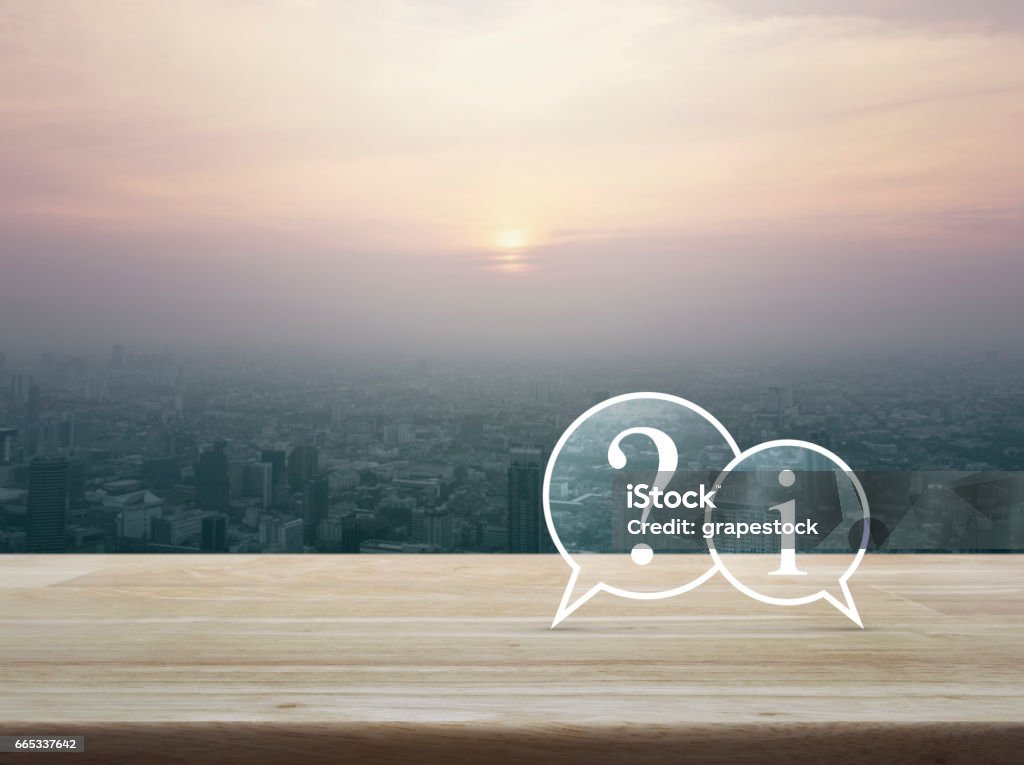 Customer support concept Question mark and information chat icon on wooden table over cityscape at sunset, vintage style, Customer support concept Q and A Stock Photo