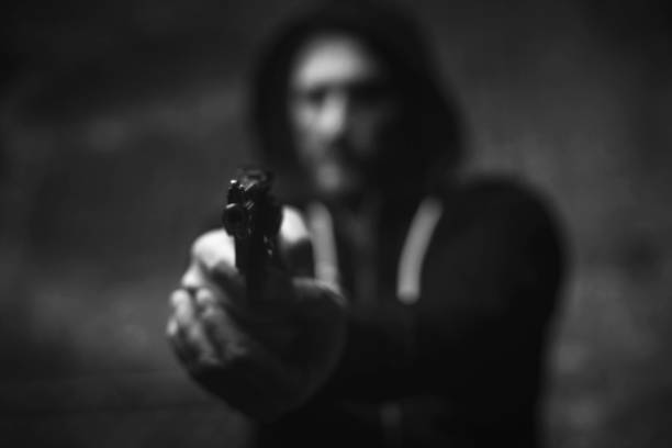 Dreaded brutal bandit holding his victim on gunpoint No escape. Raging attacking furious man menacing somebody with a weapon scaring him for getting his money armory photos stock pictures, royalty-free photos & images