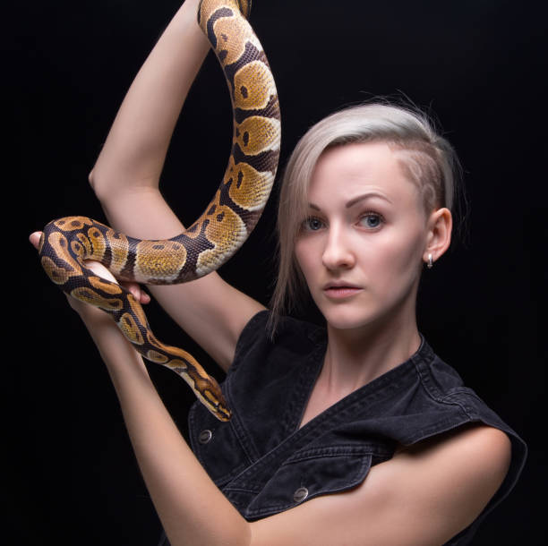 istock Blond young woman with snake 665344120