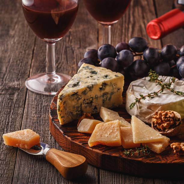 istock Cheese, nuts, grapes and red wine on wooden background 665344784