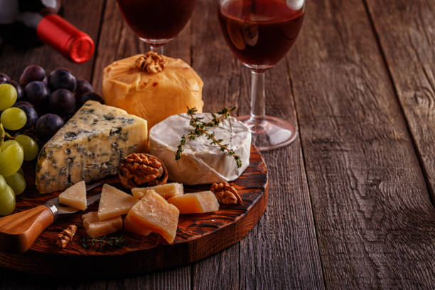 istock Cheese, nuts, grapes and red wine on wooden background 665344790