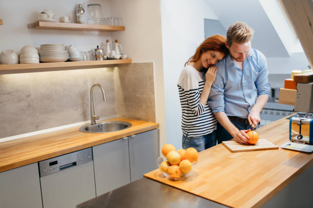 istock Happy couple making organic juice in kitchen and smiling 665345358