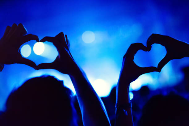 istock Couple showing hearts with hands at party 665356744