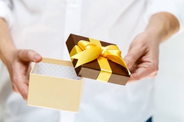 istock Male hands holding opened gift box with ribbon. 665360496
