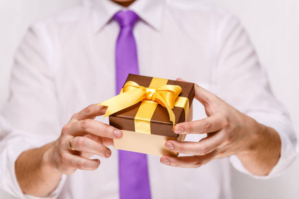 istock Male hands holding a gift box with ribbon. 665361458