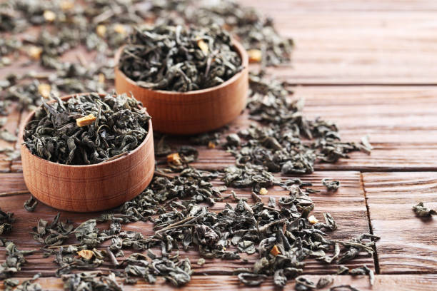 istock Heap of dry tea on brown wooden table 665361708