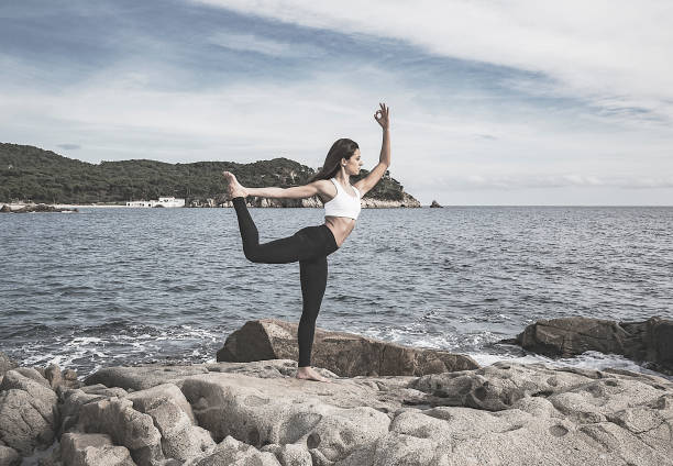 istock Woman practicing yoga at the sea 665363862